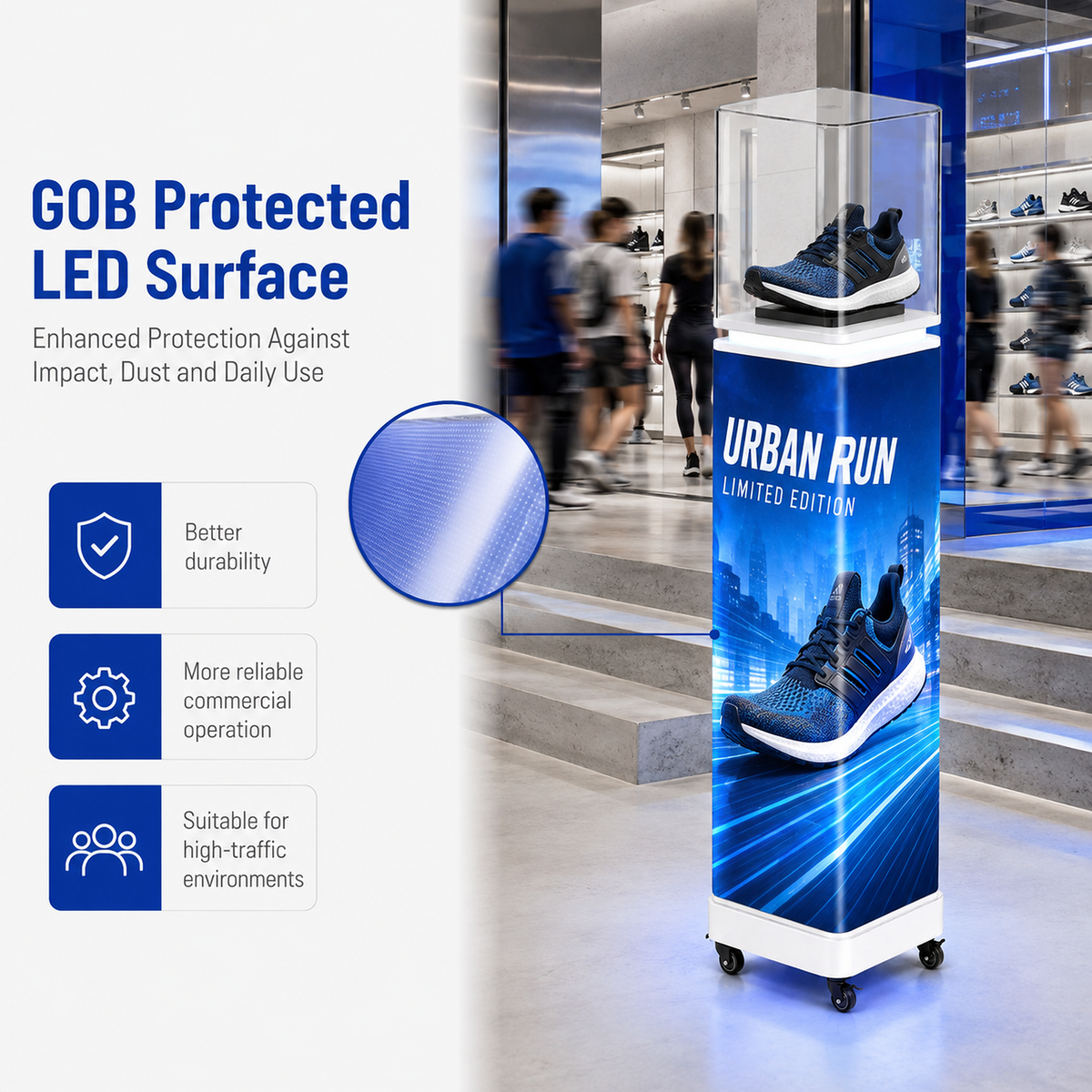 A tall freestanding retail display pedestal with a blue and black shoe advertisement wrap, shown in a shopping mall interior. The display includes a clear top case holding a sneaker and a large printed panel reading 'URBAN RUN LIMITED EDITION.