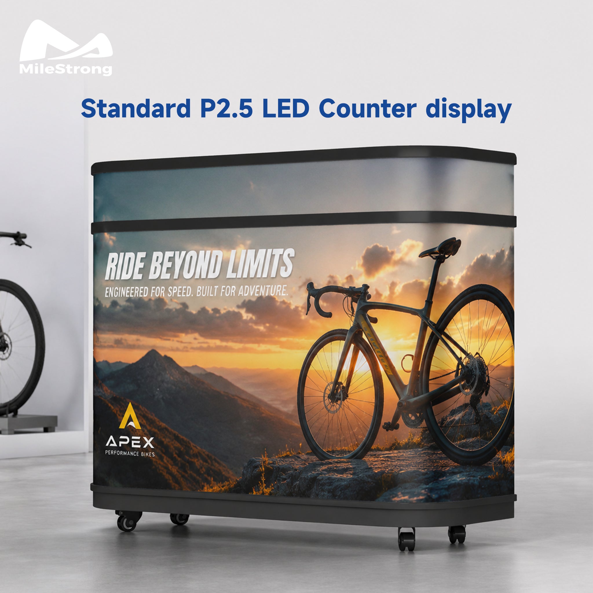 A wheeled LED counter display with a printed mountain landscape and bicycle graphic, shown in a studio setting. The display features the text 'RIDE BEYOND LIMITS' and the APEX logo, with 'MileStrong' branding at the top left.
